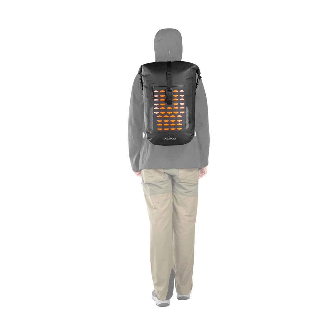 Back view of person using the 30 litre Tatonka Torrent roll-top backpack with the roll top secured to the sides of the pack - Black