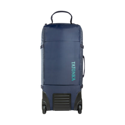Front view of Tatonka Duffel Roller with grab handle on top, compression straps at side and wheels on facing bottom edge - Navy