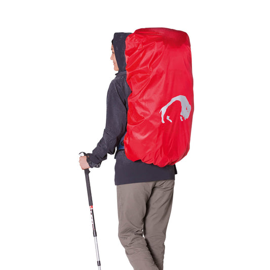 Back three quarter view of lightweight, water resistant Tatonka branded rain flap held in place on a pack using the adjustable draw cord. Packs down to 9 x 12 centimeters – Red