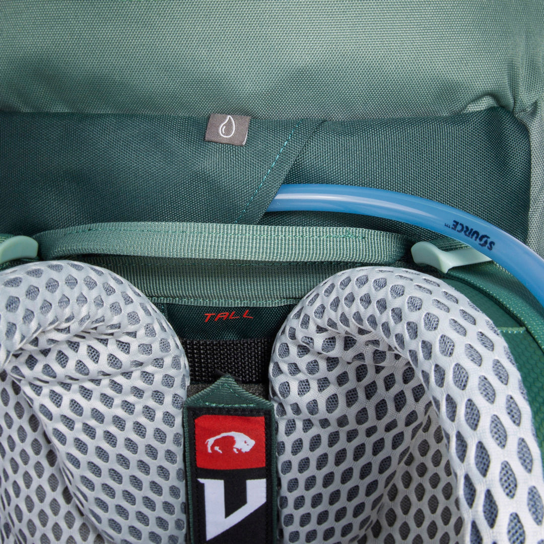Close up exterior view of hydration system showing drinking tube coming out of slot between the shoulder straps - Sage Green
