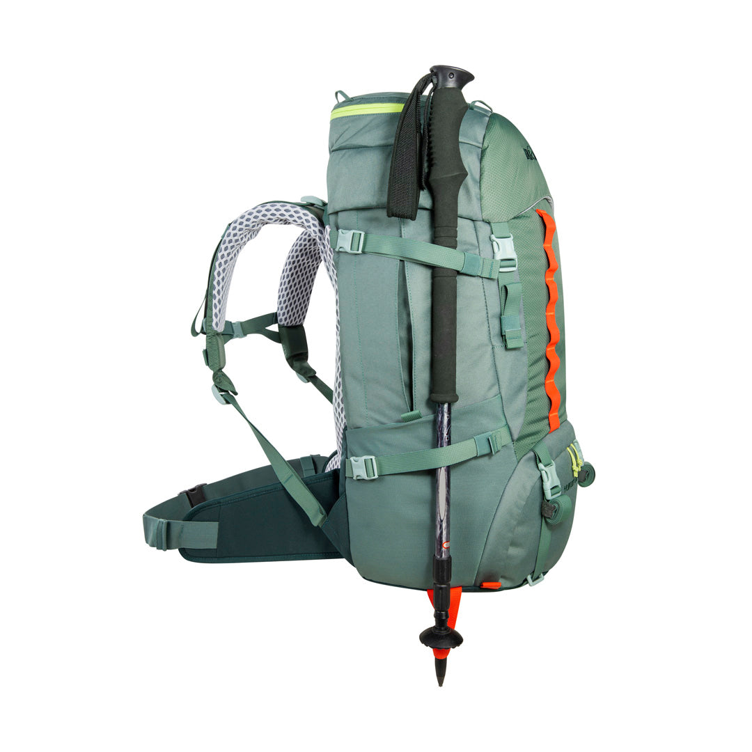 Side view of 32 litre Tatonka branded Yukon 32 JR pack showing walking pole (not included) held in place with fixation points - Sage Green