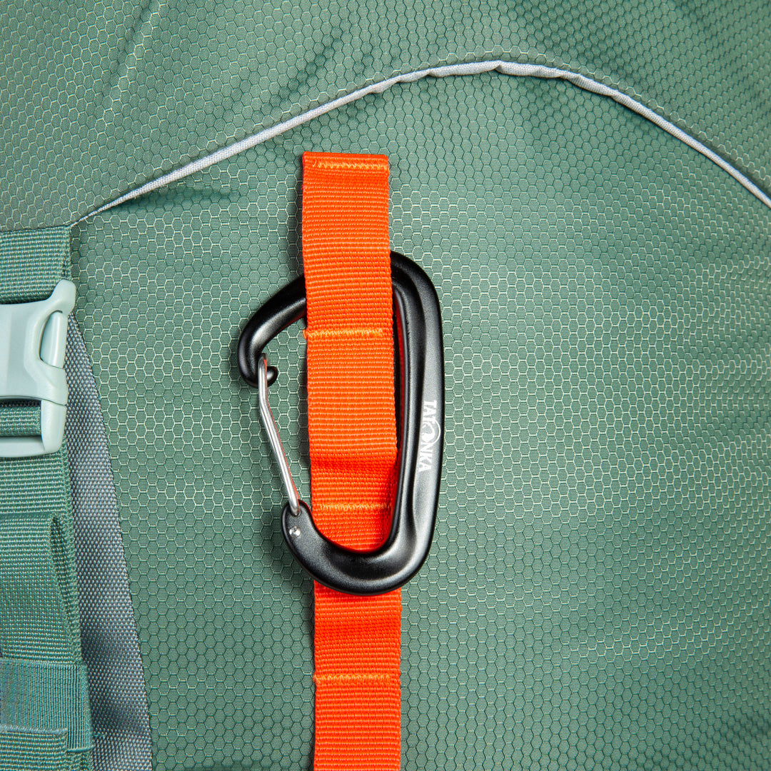 Close up of carabiner hooked through daisy chain on front of 32 litre Tatonka branded Yukon 32 JR pack – Sage Green